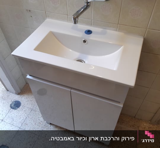 כיור לבן עם ברז בחדר אמבטיה